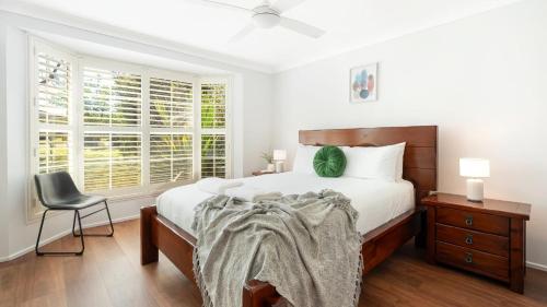 a bedroom with a bed and a chair and a window at La Playa in Myola