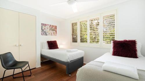 Un dormitorio con dos camas y una silla. en La Playa, en Myola