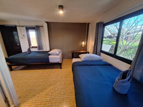 a small room with two beds and a window at So Good in Pai