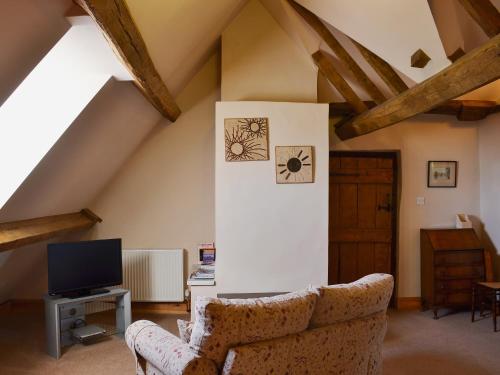 a living room with a couch and a tv at Lees Farm Apartment in Walcot