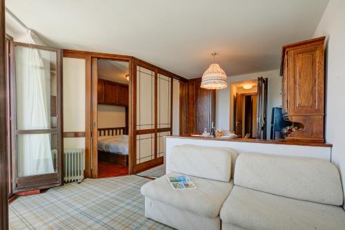a living room with a couch and a bedroom at Appartamento Principino 24 Ski in Ski out - Happy Rentals in Sestriere