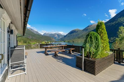 a deck with a picnic table and a view of a lake at Luxury cabin with amazing views in Stryn