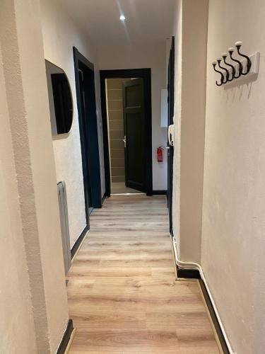 a hallway leading to a room with two doors and wood floors at Le Saint Symphorien 4 in Longeville-lès-Metz