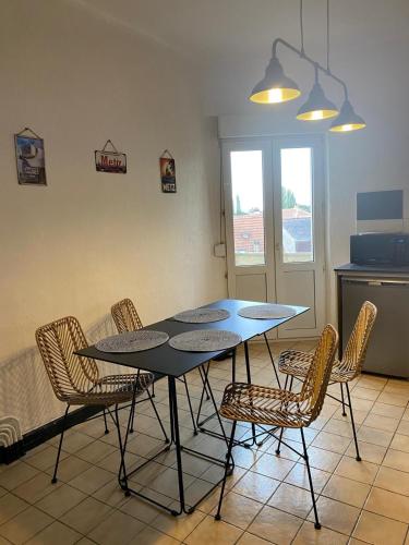 a dining room table and chairs in a kitchen at Le Saint Symphorien 4 in Longeville-lès-Metz