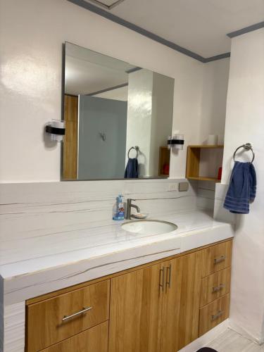 a bathroom with a sink and a large mirror at Palacios Residences in Iloilo City
