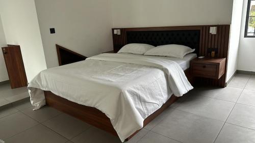 ein Schlafzimmer mit einem großen Bett mit einem hölzernen Kopfteil in der Unterkunft 120 desinganad nagar asramom in Kollam