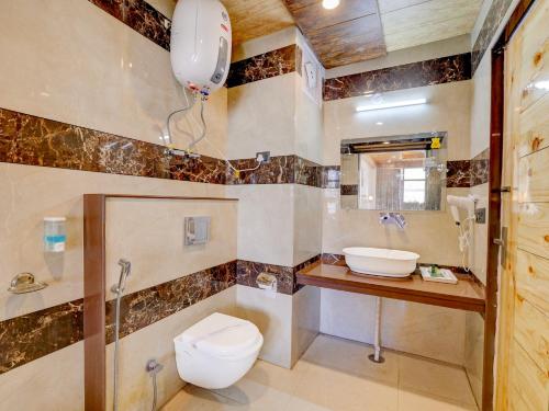 een badkamer met toilet en wastafel bij Omavya Hotel Manali in Jagatsukh