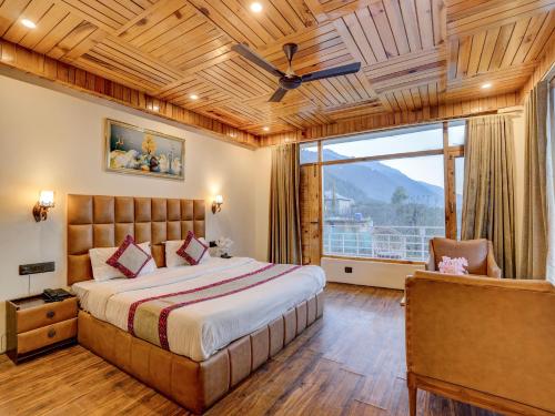 a bedroom with a bed and a large window at Omavya Hotel Manali in Jagatsukh