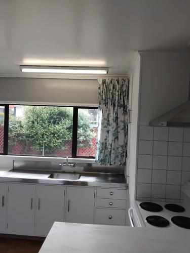 a kitchen with a sink and a window at Napier Nest Motel in Napier