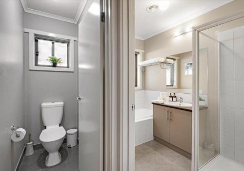 a bathroom with a toilet and a sink and a shower at LIVING LUX Ballarat, Modern 2BR Home with Garden, Free Parking in Sebastopol