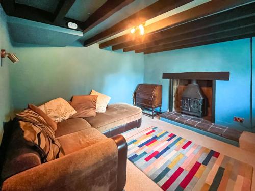 een woonkamer met een bank en een open haard bij Tyn Y Celyn - Uk48801 in Mold