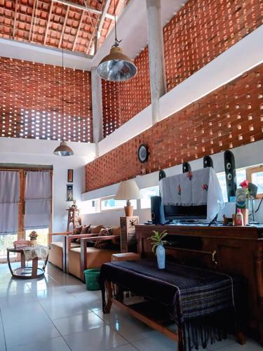 een woonkamer met een bank en een piano bij Omah Jamblangan in Cebongan