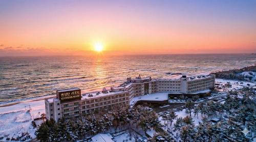 束草市肯辛顿雪岳滩度假酒店的日落时分海滩上度假村的空中景致