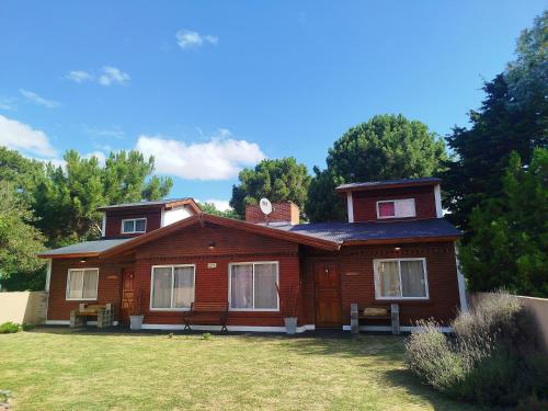 una casa de madera con un patio delante en Open Beach, en Aguas Verdes