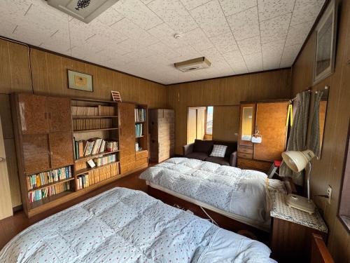 a bedroom with two beds and a couch in it at 昭和レトロの民泊 正直屋 in Chikuma