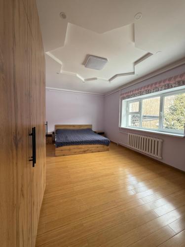 ein Schlafzimmer mit einem Bett und einem Fenster und einer Decke in der Unterkunft Villa chimbulak in Almaty