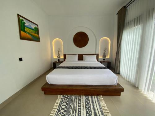 テテバトゥにあるSagunalam Tetebatuの大きなベッドとラグのある寝室