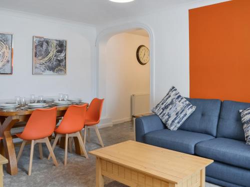 ein Wohnzimmer mit einem blauen Sofa und einem Tisch in der Unterkunft Ransdale Cottage in Bridlington