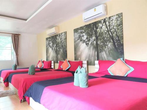 two beds in a room with pink and blue at Sea beach Koh Larn 2 Hotel in Ko Larn