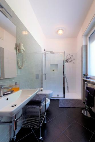 a bathroom with a sink and a toilet and a shower at B&B Villa Giuli in Varese