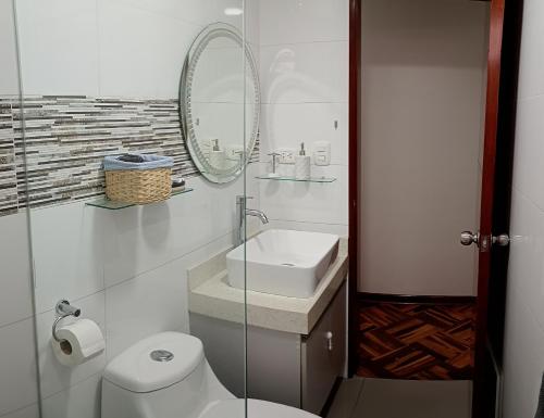 ein Badezimmer mit Toilette, Waschbecken und Spiegel in der Unterkunft Apartamento familiar amplio y cómodo en Pueblo Libre in Lima