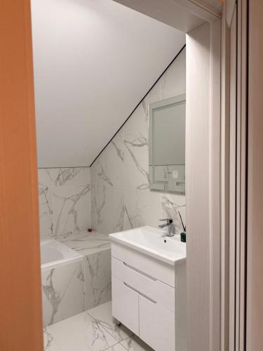 a white bathroom with a sink and a mirror at Корчин Гарден Шале in Korchin