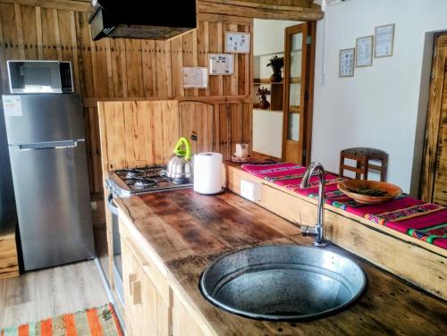 una cocina con fregadero y refrigerador en Fully furnished 1bedroom apt in the Peruvian Andes, en Sangarará