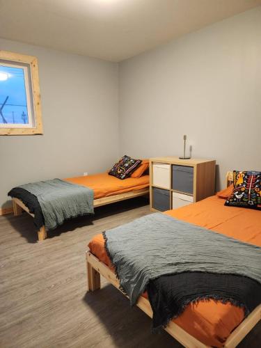 ein Schlafzimmer mit zwei Betten und einem Fenster in der Unterkunft The Bear Road in Churchill