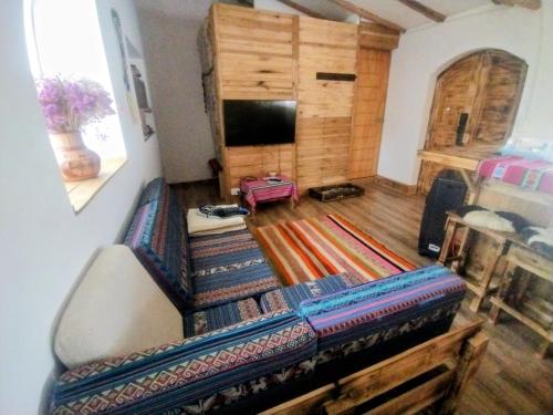 Una sala de estar con un sofá y un televisor de pantalla plana. en Fully furnished 1bedroom apt in the Peruvian Andes, en Sangarará