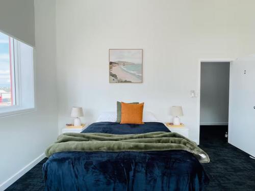 una camera da letto con un grande letto blu con due lampade di The Riverbank Suites, Central, New, Facilities a Collie