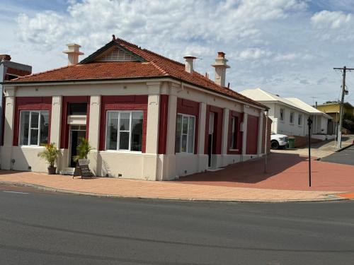 un edificio rosso e bianco all'angolo di una strada di The Riverbank Suites, Central, New, Facilities a Collie