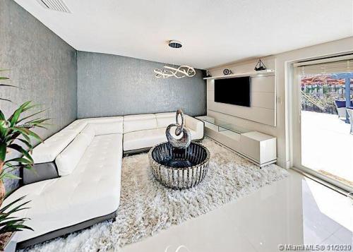 a living room with a white couch and a tv at The Chill Crib in Fort Lauderdale