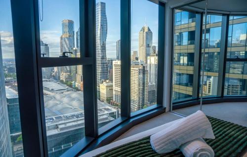 a bedroom with a view of a city skyline at 33rd Floor Deluxe 2-BR Apartment - City Views, Pool, Hot Tub & Gym in Melbourne