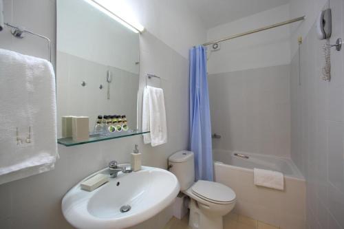 a white bathroom with a toilet and a sink at Dioscouri Hotel in Sparti