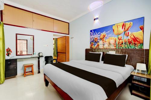a bedroom with a bed and a painting on the wall at Super Hotel O Chittoor Railway Station Formerly Four Oaks in Chittoor