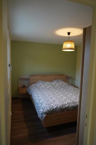 a small bedroom with a bed and a light at Cottage - La Petite Chaumière in Rouilly-Sacey