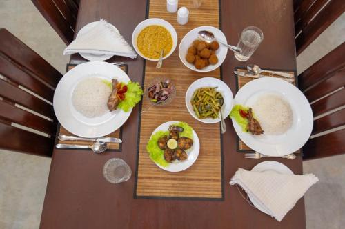NikawatawanaにあるMaygrove View Villa - Galleの食べ物の皿が置かれた木製のテーブル