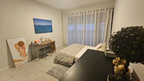 a bedroom with a bed and a desk and a window at Nou Lakaz in Rose Hill