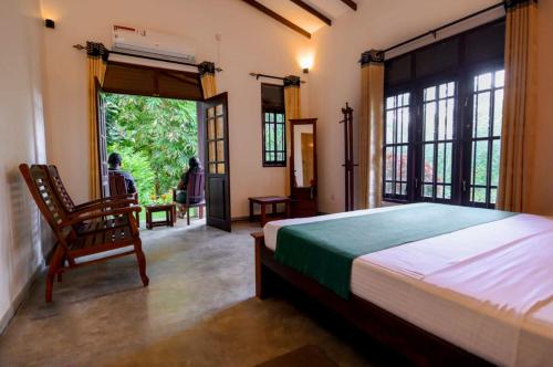 NikawatawanaにあるMaygrove View Villa - Galleのベッドと椅子と窓のある寝室