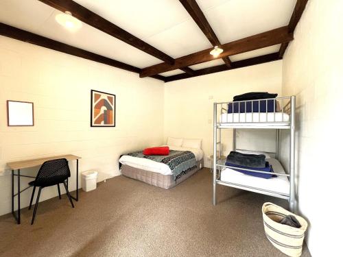 ワナカにあるMt Aspiring Holiday Parkの二段ベッドと机のある寝室