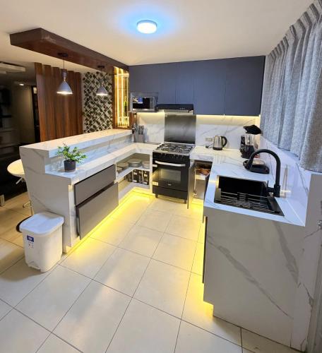 a kitchen with blue cabinets and white appliances at Dúplex céntrico y amplio, terraza cochera free in Arequipa