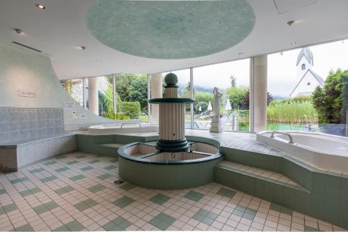 uma grande casa de banho com banheira e lavatório em Hotel Cresta em Flims