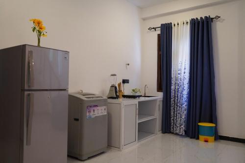 een kleine keuken met een koelkast en een tafel bij Villa Hideout in Unawatuna