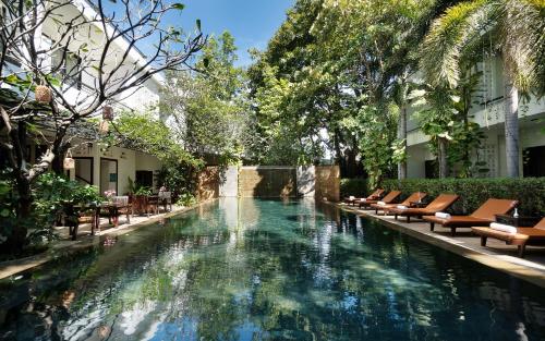 uma piscina com espreguiçadeiras e um resort em The Moon Residence & Spa em Siem Reap