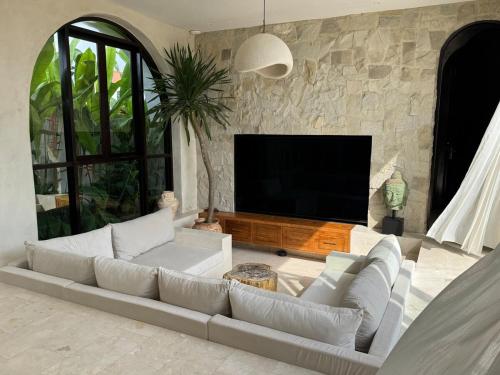 een woonkamer met een bank en een flatscreen-tv bij Villa Shugo Tenshi in Badung