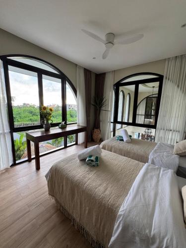 a bedroom with two beds and a large window at Villa Shugo Tenshi in Badung