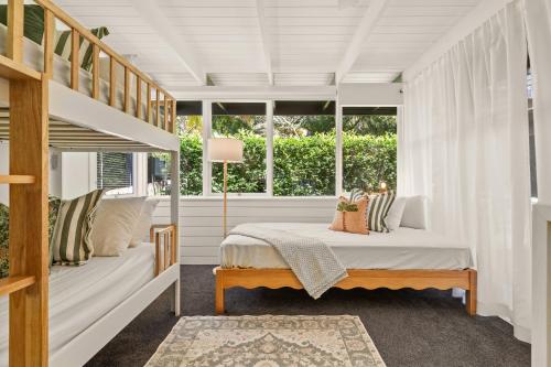 Clarevilleにある'Rosella' A Mid Century Modern House, Avalon Beachのベッドと大きな窓のある寝室