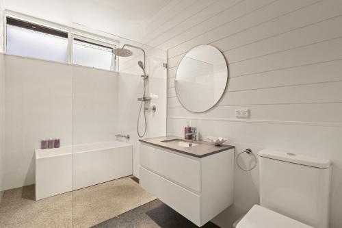 Clarevilleにある'Rosella' A Mid Century Modern House, Avalon Beachの洗面台と鏡のある白いバスルーム