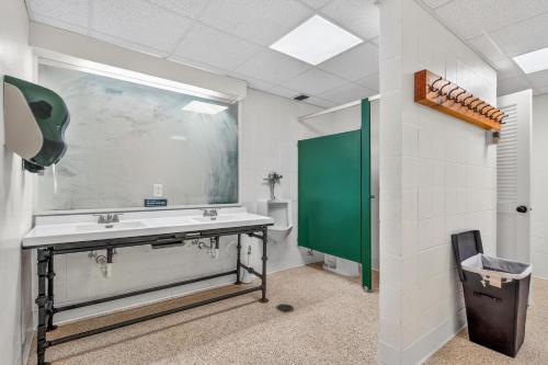 a bathroom with a sink and a green mirror at Pinnacle F21 in Killington