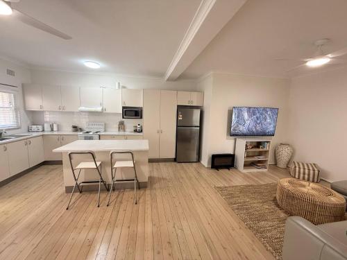 a kitchen and living room with a table and chairs at Stunning Ground Floor Apt with Ocean Views in Cronulla